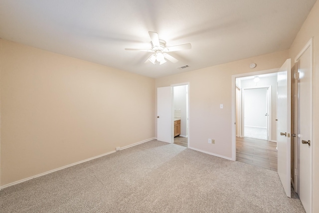 unfurnished bedroom with connected bathroom, ceiling fan, and light carpet