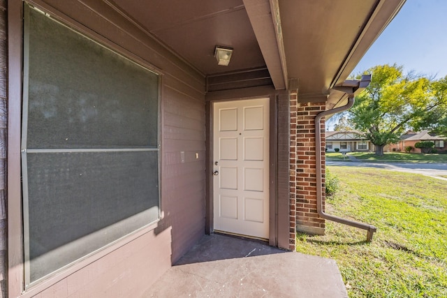 property entrance with a lawn