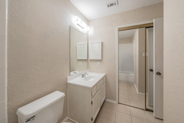 full bathroom with washtub / shower combination, vanity, toilet, and tile patterned flooring