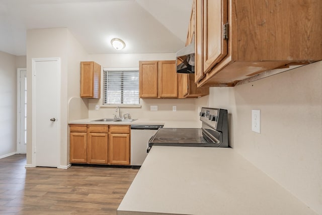 kitchen featuring sink, stainless steel appliances, lofted ceiling, and light hardwood / wood-style floors