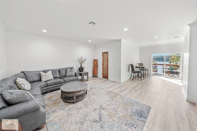 living room featuring light wood-type flooring and ornamental molding