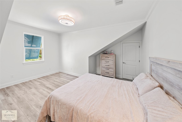 bedroom featuring light hardwood / wood-style floors and crown molding