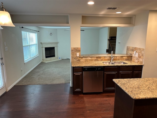 kitchen with dark colored carpet, dark brown cabinets, stainless steel dishwasher, and sink