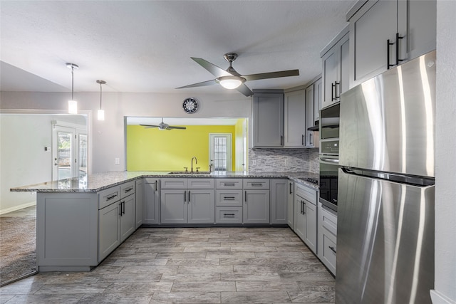 kitchen with appliances with stainless steel finishes, gray cabinetry, and ceiling fan