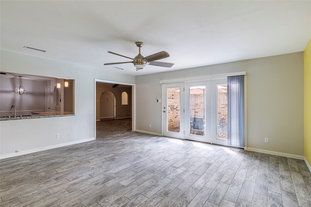 unfurnished living room featuring ceiling fan, light hardwood / wood-style floors, and sink