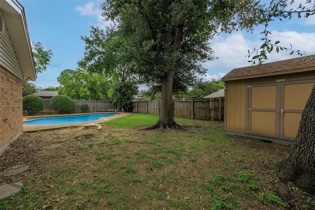 view of yard with a fenced in pool and a storage unit