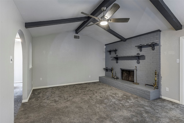 unfurnished living room featuring ceiling fan, dark colored carpet, a brick fireplace, and vaulted ceiling with beams