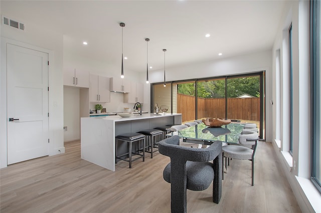 dining space with sink and light hardwood / wood-style floors