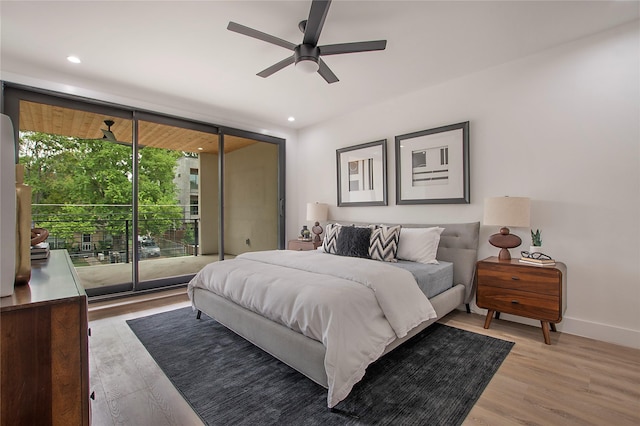 bedroom with baseboards, access to exterior, a wall of windows, and light wood finished floors