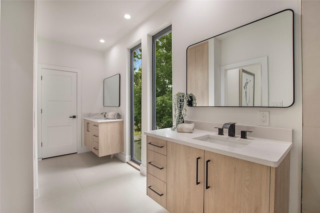 bathroom with recessed lighting, a sink, and two vanities