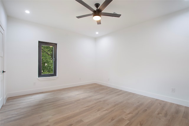 empty room with ceiling fan and light hardwood / wood-style flooring