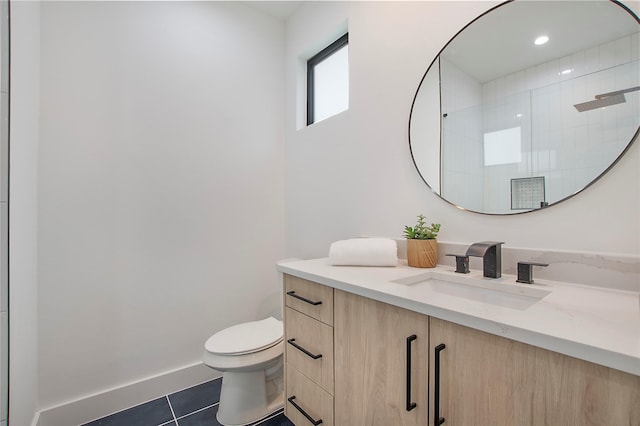 bathroom featuring baseboards, toilet, vanity, a stall shower, and tile patterned flooring