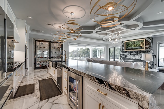 kitchen featuring beverage cooler, white cabinets, a chandelier, and ornamental molding