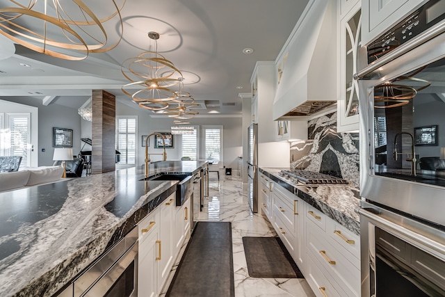 kitchen with pendant lighting, white cabinets, and custom exhaust hood