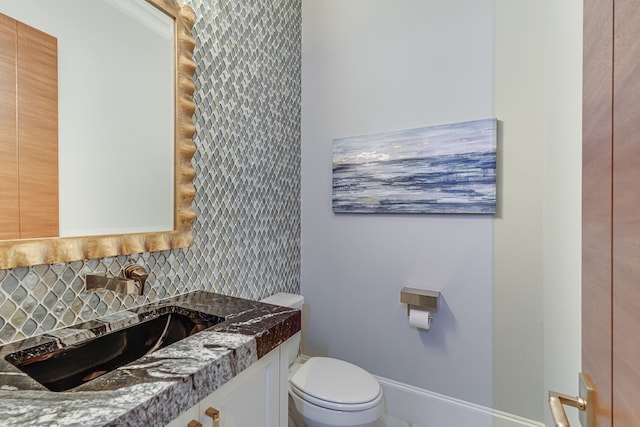 bathroom featuring backsplash, toilet, and vanity