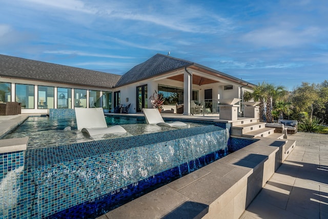 view of swimming pool with area for grilling, pool water feature, and a patio area