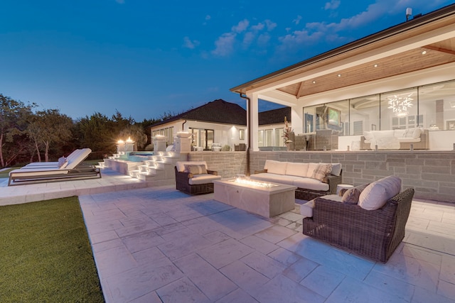 patio at twilight with an outdoor living space with a fire pit