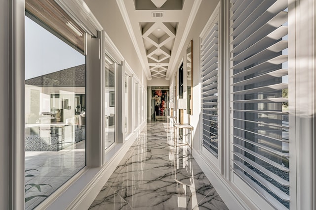 corridor with ornamental molding and beamed ceiling