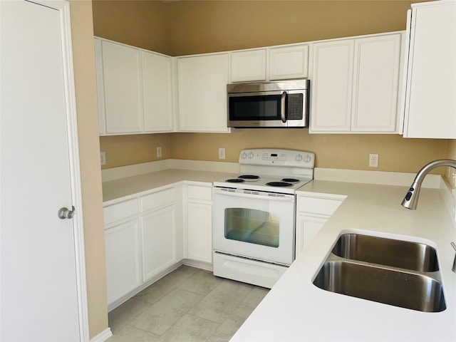 kitchen featuring sink, light tile patterned floors, white range with electric cooktop, and white cabinets