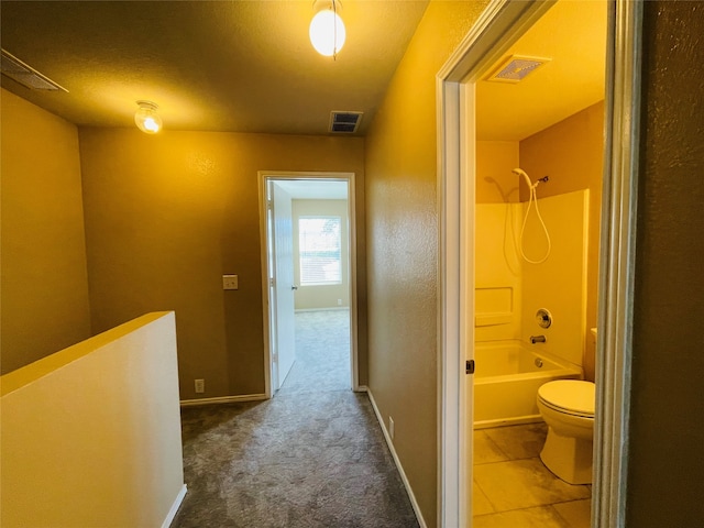 bathroom featuring a textured ceiling, toilet, and shower / tub combination