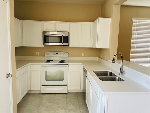 kitchen featuring appliances with stainless steel finishes, kitchen peninsula, sink, and white cabinets