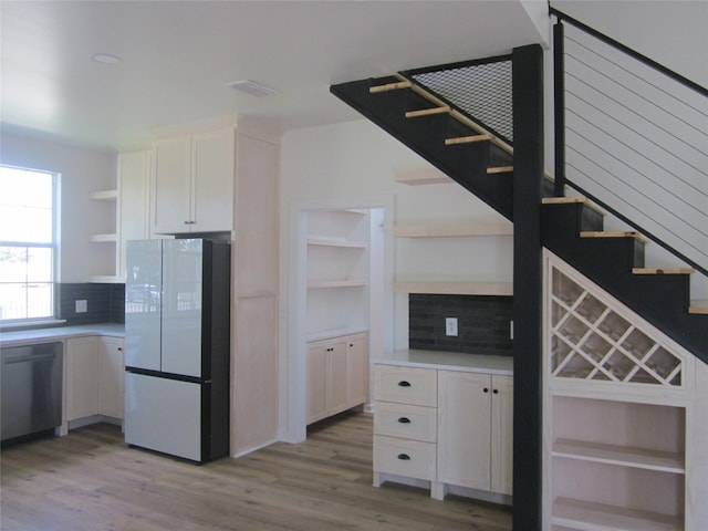kitchen with visible vents, open shelves, freestanding refrigerator, dishwasher, and backsplash