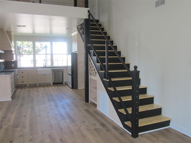 stairway with visible vents and wood finished floors