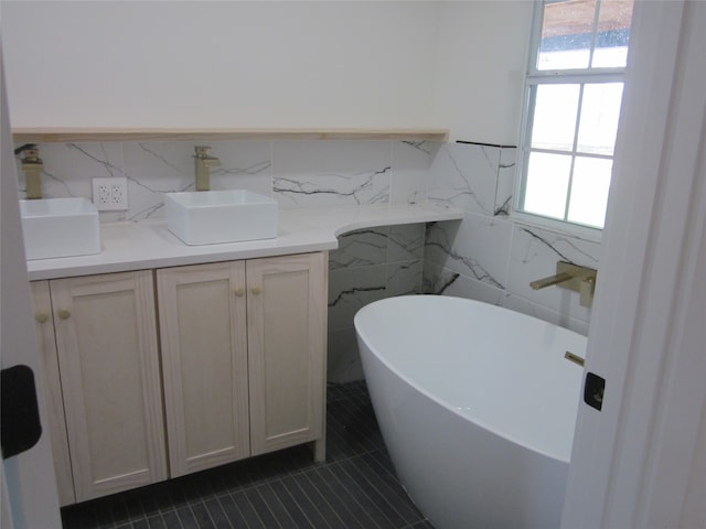 bathroom featuring vanity, a bath, a healthy amount of sunlight, and tile walls