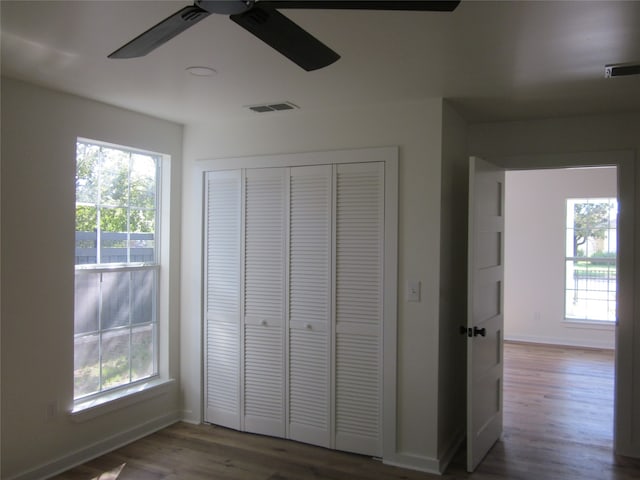 unfurnished bedroom with a closet, ceiling fan, and hardwood / wood-style flooring