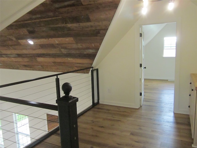 stairway featuring lofted ceiling, wood-type flooring, and wooden ceiling