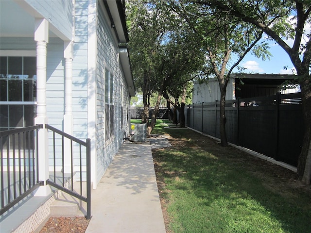 view of home's exterior featuring a lawn, cooling unit, and fence private yard