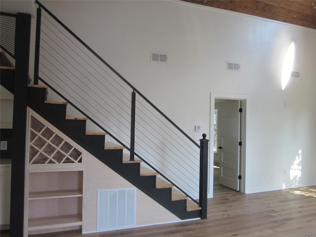 stairs with visible vents, baseboards, and wood finished floors