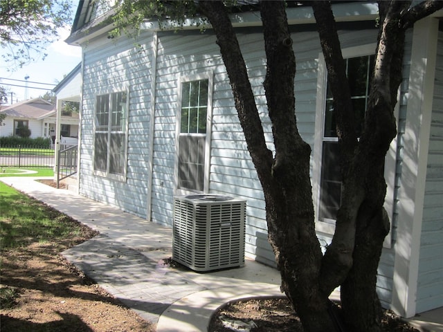 exterior details featuring central AC and fence