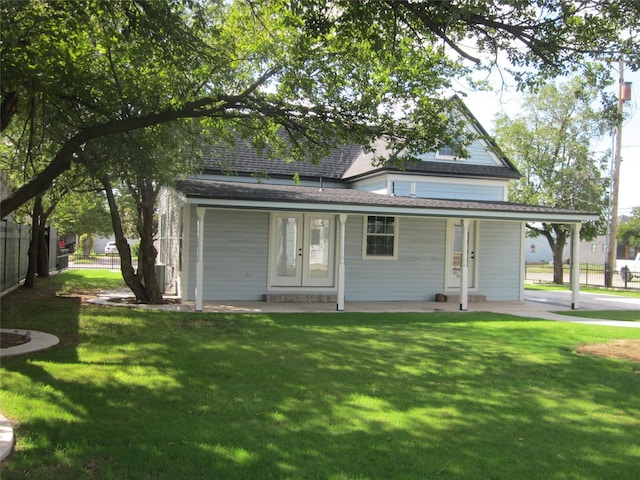 rear view of house featuring a lawn, fence, and a shingled roof