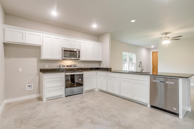 kitchen with light carpet, ceiling fan, appliances with stainless steel finishes, white cabinetry, and sink