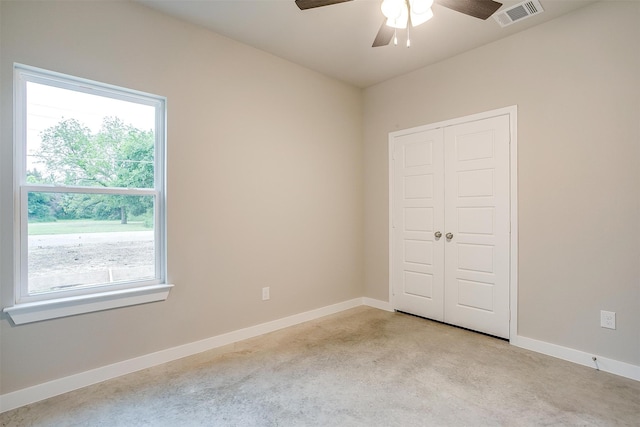 unfurnished bedroom featuring a closet, ceiling fan, and light carpet