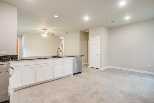 kitchen with dishwasher, dark stone countertops, sink, white cabinetry, and ceiling fan