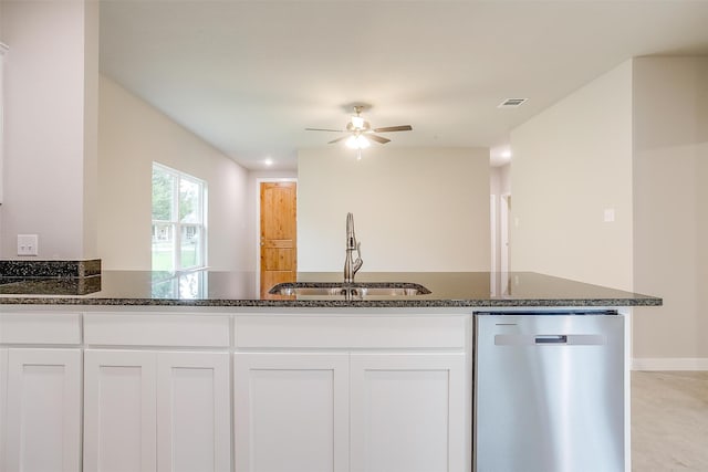 kitchen with ceiling fan, white cabinetry, dark stone counters, dishwasher, and sink