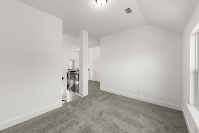 spare room featuring carpet, plenty of natural light, and lofted ceiling