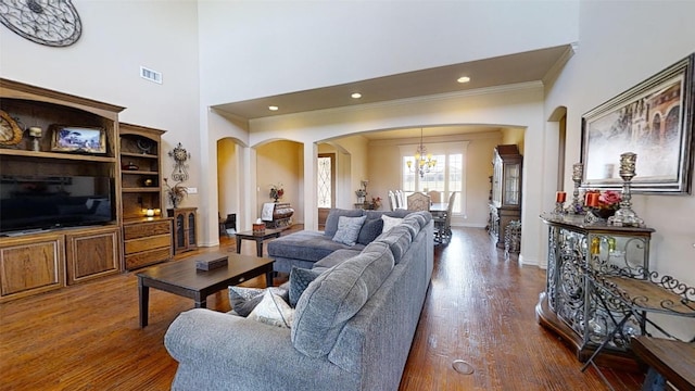 living room with ornamental molding, a chandelier, and dark hardwood / wood-style flooring