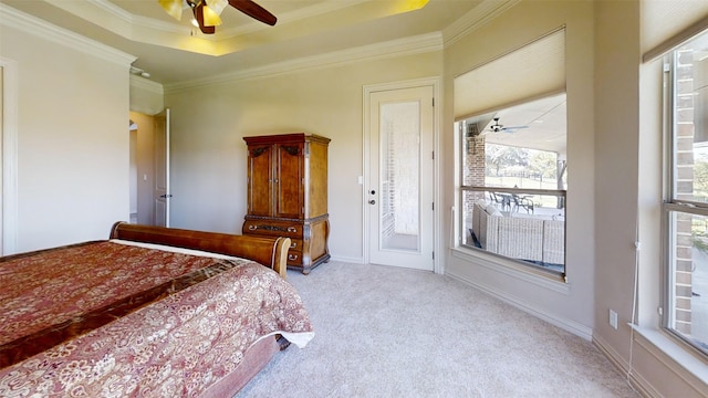 carpeted bedroom with crown molding, a tray ceiling, access to outside, and ceiling fan