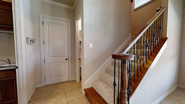 tiled entrance foyer featuring ornamental molding