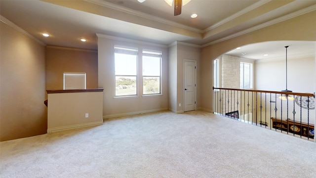 spare room featuring ceiling fan, crown molding, and light carpet