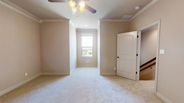 spare room with ornamental molding, ceiling fan, and light colored carpet