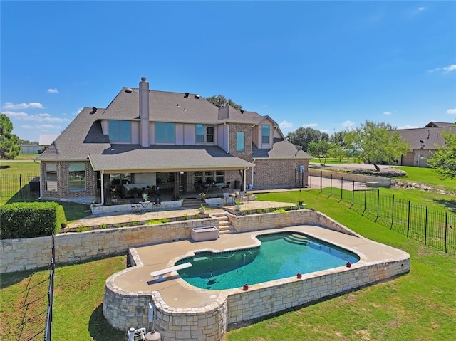 view of pool with a diving board, a lawn, and a patio