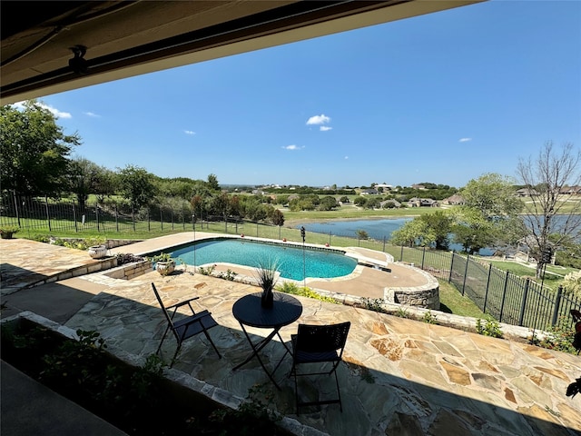 view of swimming pool with a patio and a water view