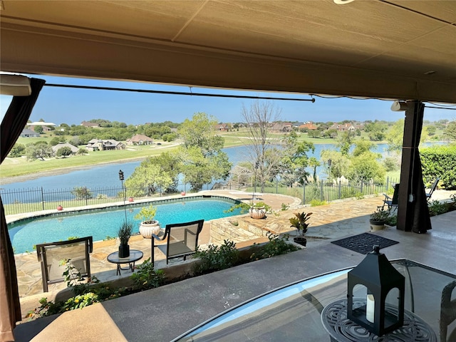 view of swimming pool featuring a patio and a water view