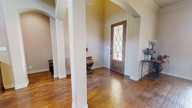 foyer featuring ornamental molding and dark hardwood / wood-style flooring