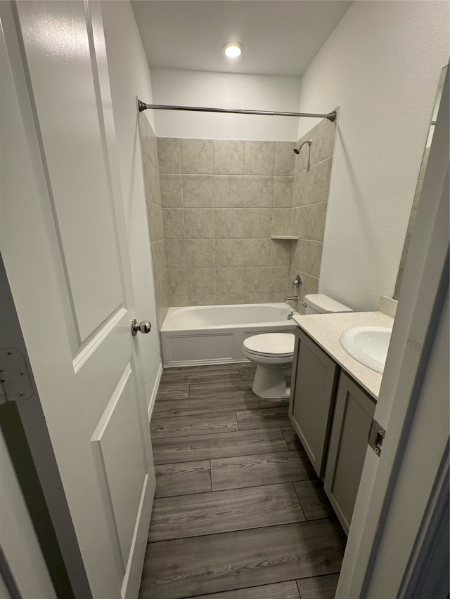 full bathroom featuring vanity, toilet, tiled shower / bath combo, and hardwood / wood-style floors