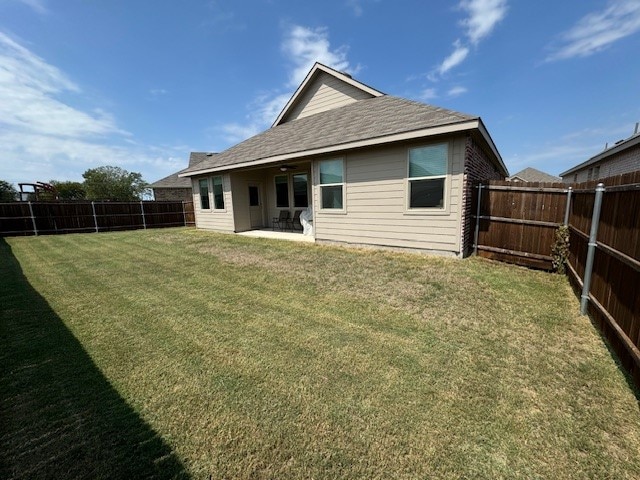 rear view of house featuring a lawn